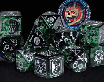 Könnte beinhalten: Ein Set aus grün-schwarzen Würfeln mit silbernen Details, die Schädel und andere gotische Symbole zeigen. Die Würfel sind in einem Haufen angeordnet, mit einem kreisförmigen Emblem mit der Aufschrift "Crypt of the Necromancer" im Hintergrund. Für Tabletop-Spiele.
