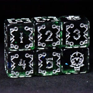 May include: Six black and green dice with silver numbering and symbols. The dice are arranged in two rows of three. Each die has a different number from one to five, or a skull symbol.
