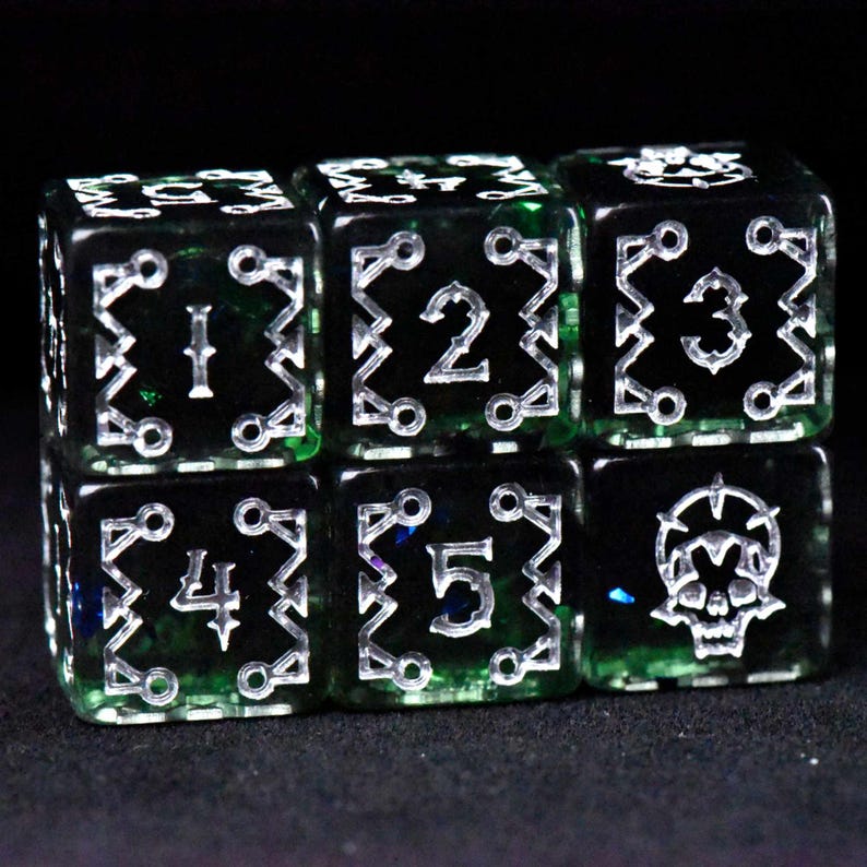 May include: Six black and green dice with silver numbering and symbols. The dice are arranged in two rows of three. Each die has a different number from one to five, or a skull symbol.