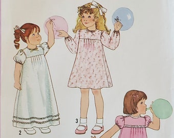 Puede incluir: Patrón de costura Simplicity número 8896 para un vestido de niña. El patrón muestra tres estilos diferentes de vestidos, todos con un dobladillo con volantes. Los vestidos son blancos, rosas y con estampado floral. El patrón es para una niña de talla 6.