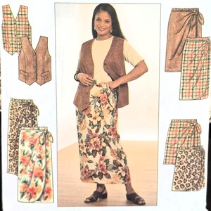 May include: A Simplicity sewing pattern, size GG, featuring a woman wearing a floral wrap skirt, a brown vest, and a cream-colored top. The pattern includes illustrations of wrap skirts and vests in various patterns. The text "Simplicity" is prominently displayed.