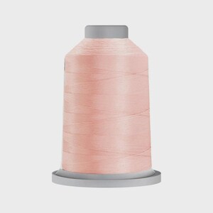 May include: A spool of pale pink thread for sewing or embroidery.