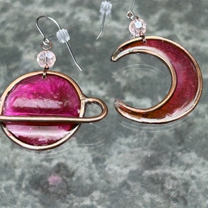 May include: A white ceramic mug with a black handle and the text "But First, Coffee" in a black, handwritten-style font. The mug is on a white surface.