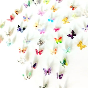 May include: A white background with a variety of colorful butterflies scattered across the surface. The butterflies are made of paper and have different patterns and designs.