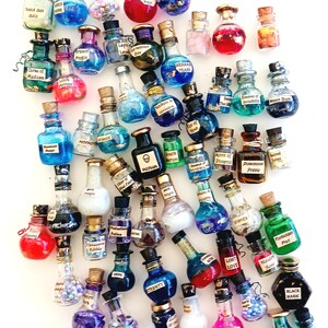 May include: A collection of small glass bottles with cork stoppers, filled with colorful liquids and glitter. Each bottle has a different label with a magical or mystical inscription, such as "Love Potion", "Mermaid Tears", and "Black Magic".