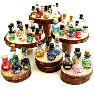 May include: A collection of miniature glass bottles filled with colorful liquids and powders, each featuring a cork stopper and a small paper label with text such as Fire Spirit, Witches Brew, Unicorn Magic, Poison, Love Spell, and Forbidden Fruit.