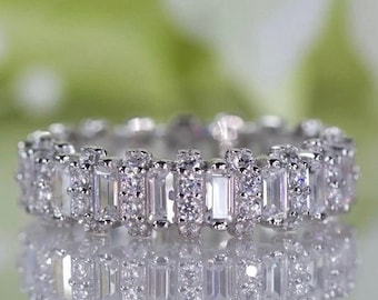 Puede incluir: Un anillo de banda de plata con una fila de piedras de circonita cúbica de forma baguette engastadas en pavé.