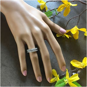 Puede incluir: Un anillo de plata con dos filas de peque&ntilde;as piedras de circonita c&uacute;bica transparentes.