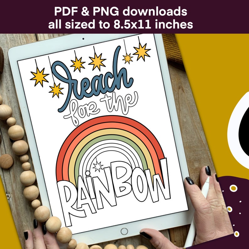 May include: A digital illustration on a tablet featuring the text "Reach for the Rainbow" above a colorful rainbow design. The image is sized to 8.5x11 inches. The tablet is held by a person's hands.
