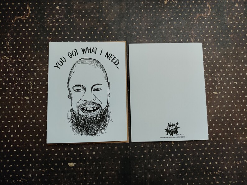 May include: Greeting card with a black and white illustration of a smiling face with a beard and the text "YOU GOT WHAT I NEED...". The card is blank on the inside and has a logo on the back.