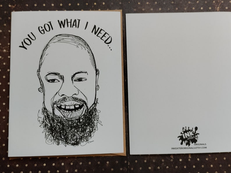 May include: A greeting card with a black and white line drawing of a smiling person with a beard. The text "YOU GOT WHAT I NEED..." is above the drawing. A blank card is next to it.