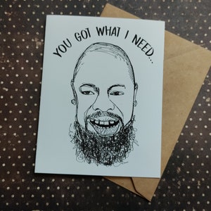 May include: A white greeting card with a black and white line drawing of a smiling person with a beard. The text "YOU GOT WHAT I NEED..." is above the drawing. The card is inside a brown envelope.
