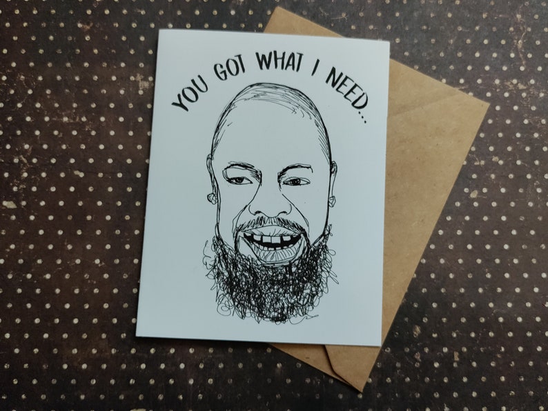 May include: A white greeting card with a black and white line drawing of a smiling person with a beard. The text "YOU GOT WHAT I NEED..." is above the drawing. The card is inside a brown envelope.