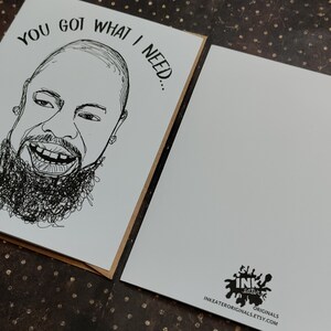 May include: Greeting card with a black and white sketch of a smiling person with a beard. The text "YOU GOT WHAT I NEED..." is above the face. The back of the card is blank with a logo and website address.