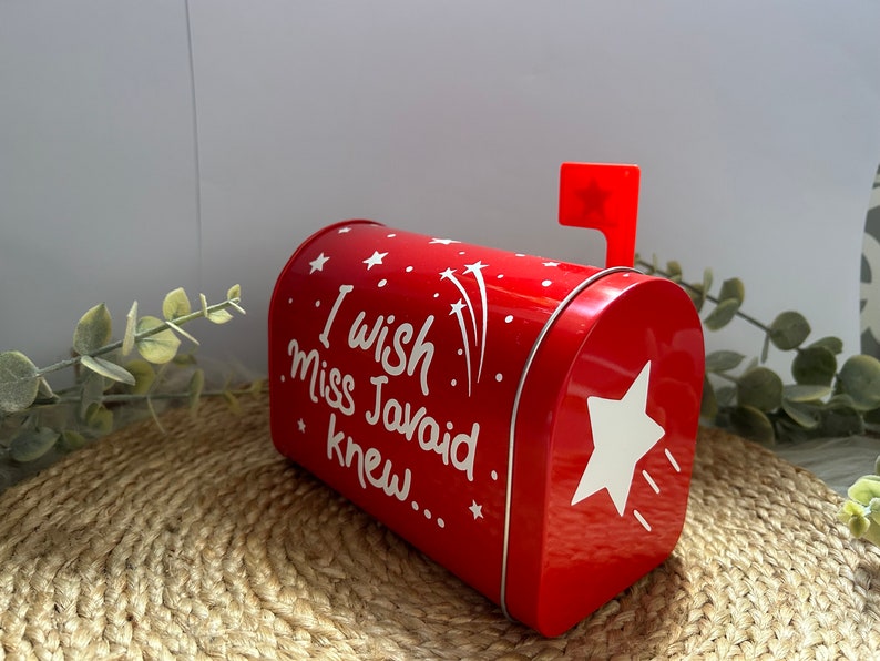 May include: Red metal mailbox with a white star and the text "I wish Miss Javaid knew..." on the front. The mailbox has a red flag with a white star on top.
