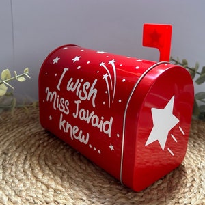 May include: Red metal mailbox with a white star and the text "I wish Miss Javaid knew..." on the side. The mailbox has a red flag on top.
