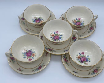 May include: Set of five vintage teacups and saucers with a floral pattern in shades of pink, blue, and yellow. The cups and saucers have a gold trim.