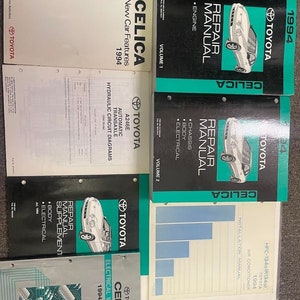 May include: A set of eight Toyota Celica repair manuals for the 1994 model year. The manuals are colour-coded and cover various aspects of the car, including the engine, chassis, body, electrical system, and air conditioning.