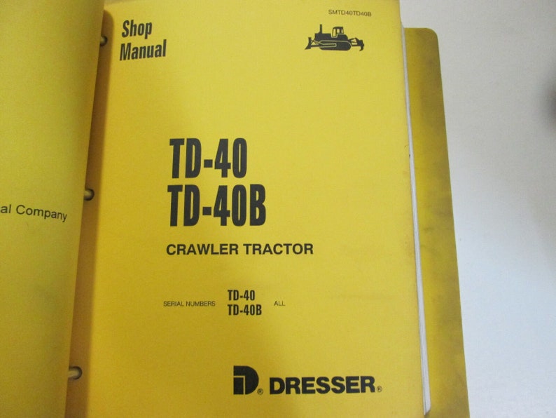 May include: Yellow cover of a shop manual for the TD-40 and TD-40B crawler tractors. The cover features a black and white illustration of a crawler tractor and the text "Shop Manual", "TD-40", "TD-40B", "Crawler Tractor", "Serial Numbers", "TD-40", "TD-40B", "ALL", and "D. DRESSER."