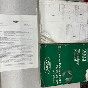 Könnte beinhalten: Ein grünes und weißes Ford-Werkstatthandbuch für die Modelle Excursion, F-Super Duty 250, 350, 450 und 550 aus dem Jahr 2004. Das Handbuch ist Band 2.