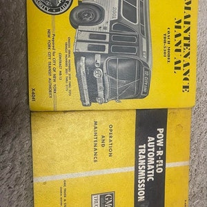 May include: Two yellow maintenance manuals for a GMC TDH-5301 coach model bus. The top manual is titled "Maintenance Manual" and the bottom manual is titled "Pow-R-Flo Automatic Transmission, Operation and Maintenance".