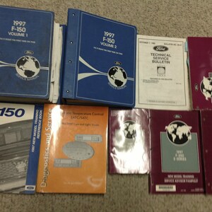 Può includere: Una collezione di otto manuali di assistenza e bollettini di servizio tecnico Ford F-150 blu, bordeaux e grigi. I manuali sono per l'anno modello 1997 e includono informazioni su diagnostica, assistenza e formazione per nuovi modelli.