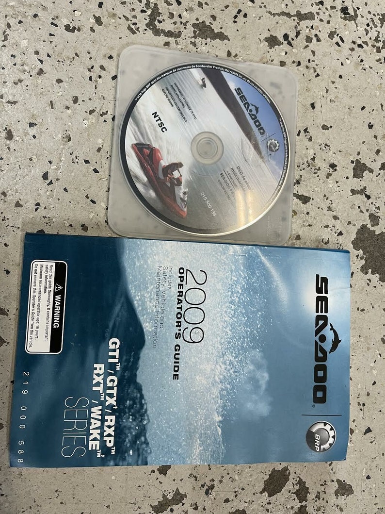 Puede incluir: Un manual de operador Sea-Doo azul y blanco para las series GTI, GTX, RXP, RXT y Wake de 2009. El manual incluye informaci&oacute;n de seguridad, veh&iacute;culo y mantenimiento. La portada presenta un delf&iacute;n y el logotipo de BRP.