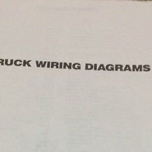 Pode incluir: Close-up de uma página branca com o texto "1990 TRUCK WIRING DIAGRAMS" impresso em preto.