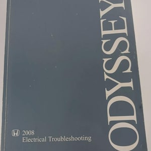 Puede incluir: Una cubierta azul para un manual de resolución de problemas eléctricos de Honda Odyssey 2008. La cubierta tiene la palabra "ODYSSEY" impresa en blanco, verticalmente hacia abajo en el lado derecho.