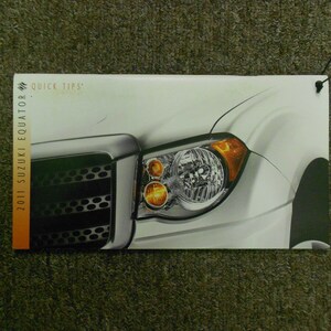 May include: A close-up of the front of a white 2011 Suzuki Equator with the text "Quick Tips" and "2011 Suzuki Equator" printed on the side. The headlights are on and the grille is visible.