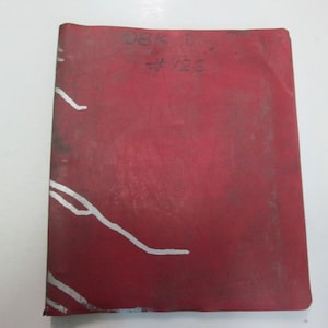 May include: Red binder with white lines and the text "38K 6/27 #126" on the front cover.