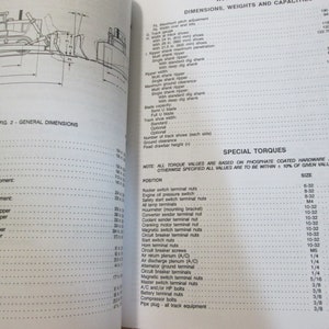 May include: A black and white technical manual with a diagram of a bulldozer and a table of dimensions, weights, and capacities. The table lists measurements in inches and millimeters. The manual also includes a section on special torques with a table listing torque values for various sizes of bolts and screws.