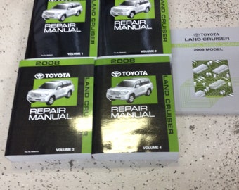 Può includere: Quattro manuali di riparazione neri e verdi per un Toyota Land Cruiser 2008, etichettati con i volumi da 1 a 4. È anche mostrato uno schema elettrico grigio per un Toyota Land Cruiser 2008.