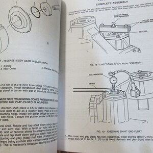 May include: A black and white illustration of a car part assembly process. The illustration shows the steps involved in installing a reverse idler gear, directional shaft, and checking shaft end float. The illustration includes text labels for each step, such as "Reverse Idler Gear Installation", "Directional Shaft Push Operation", and "Checking Shaft End Float".