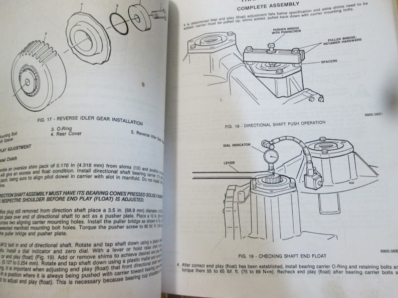 May include: A black and white illustration of a car part assembly process. The illustration shows the steps involved in installing a reverse idler gear, directional shaft, and checking shaft end float. The illustration includes text labels for each step, such as "Reverse Idler Gear Installation", "Directional Shaft Push Operation", and "Checking Shaft End Float".