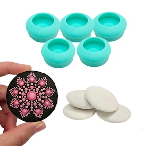 May include: Set of five turquoise silicone molds for creating dot art, along with four white blank round ceramic tiles and a finished dot art tile with a pink flower design on a black background.