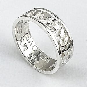 May include: A silver ring with a textured band and cut-out design. The ring has the words "I LOVE MY" engraved on the inside. The ring is made of a shiny, reflective metal.