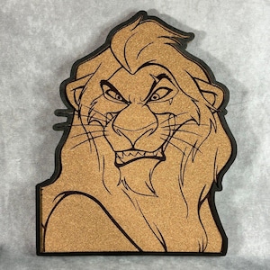 May include: A wooden cutout of a lion's head with a black outline and a cork-like texture. The lion has an angry expression with visible teeth and furrowed brows. The cutout is a decorative item.