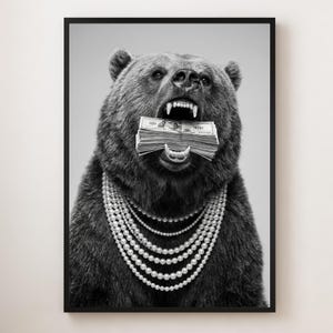 Op de afbeelding: Zwart-wit ingelijste print met een beer die een stapel honderd dollar biljetten in zijn bek heeft en meerdere parelkettingen om zijn nek draagt. De afbeelding toont de vachttextuur van de beer en een contrastrijke stijl.