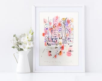 Puede incluir: Una pintura de acuarela enmarcada de una escena urbana con edificios altos en tonos rosa, morado y naranja. La obra de arte incluye detalles de líneas negras y el texto "Walking in the New York City". Un jarrón blanco con flores está a la izquierda.