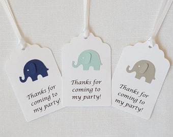 May include: Three white favor tags with scalloped edges and blue, green, and gray paper elephants. Each tag has the text "Thanks for coming to my party!"