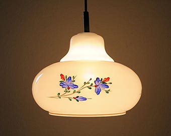 May include: White pendant light fixture with a floral design. The flowers are blue, red, and yellow. The light fixture is hanging from a ceiling.