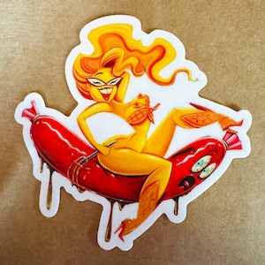 May include: A sticker featuring a cartoon illustration of a yellow figure with orange hair riding a red sausage. The figure is holding a fork and wearing a red bandana. The sausage has cartoon eyes and dripping brown sauce.