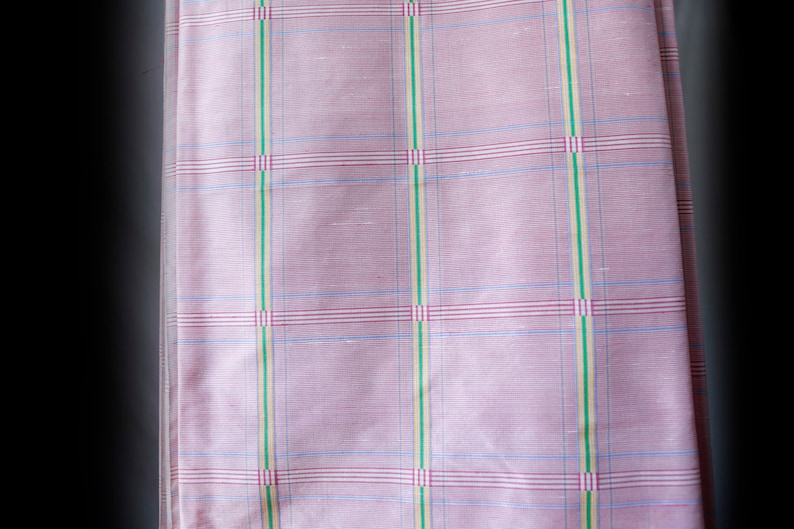 May include: Pink fabric with a checkered pattern in shades of blue, green, and red.