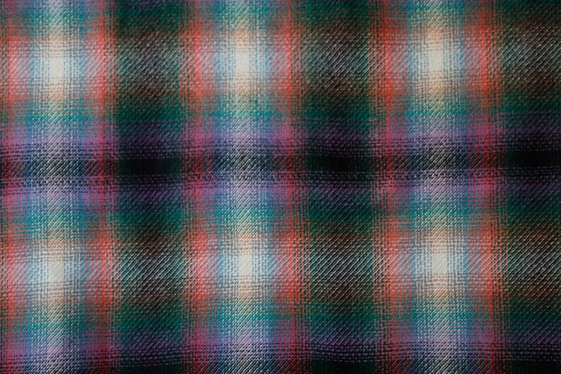 May include: A close-up of a fabric with a plaid pattern in shades of green, red, pink, and white.