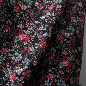 Pu&ograve; includere: Tessuto nero con stampa floreale a piccolo disegno con fiori rossi, rosa, blu e bianchi. Il tessuto ha un sottile motivo a pois.