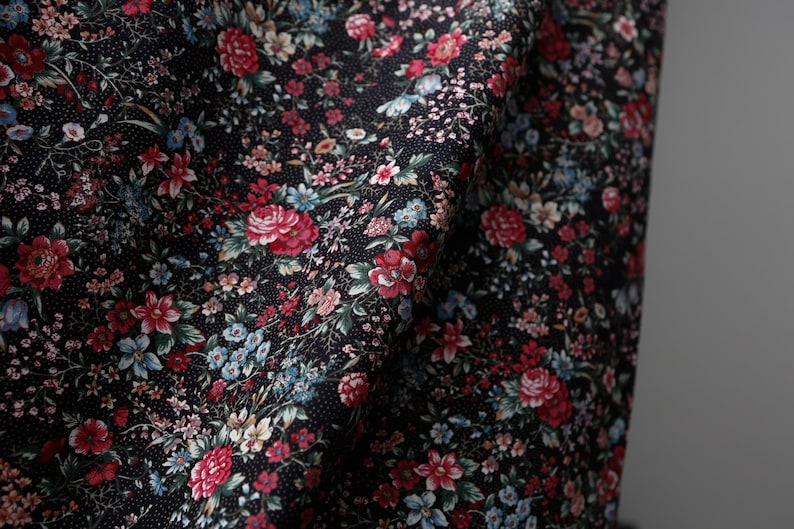 Pu&ograve; includere: Tessuto nero con stampa floreale a piccolo disegno con fiori rossi, rosa, blu e bianchi. Il tessuto ha un sottile motivo a pois.