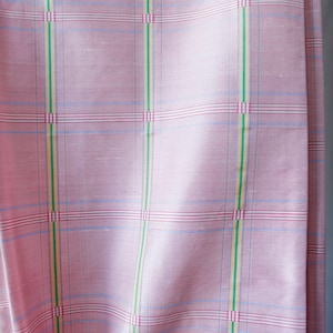May include: Pink fabric with a checkered pattern in blue, red, green, and yellow.