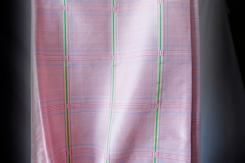May include: Pink fabric with a checkered pattern in blue, red, green, and yellow.