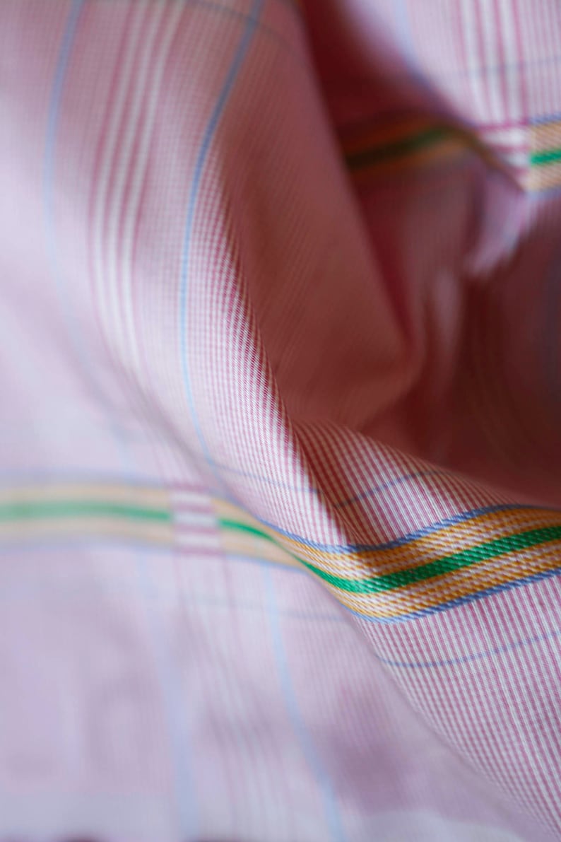 May include: Pink and white checkered fabric with thin red stripes and a thicker green, yellow, and blue stripe.